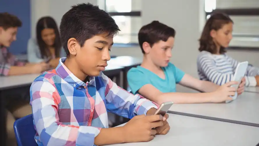 Group of students reading on smartphones and tablets